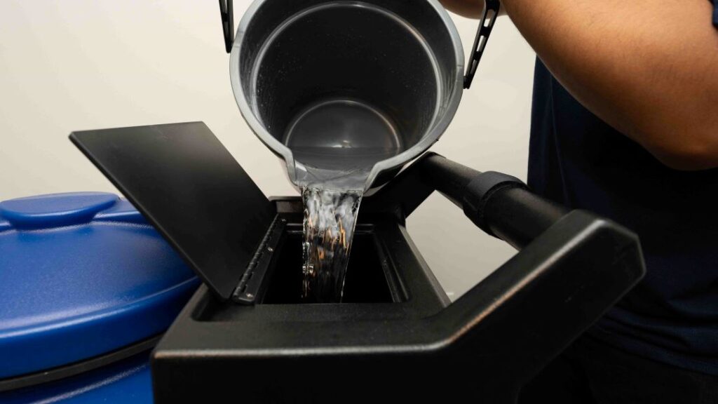 A clean bucket of water pouring into the carpet excavator.